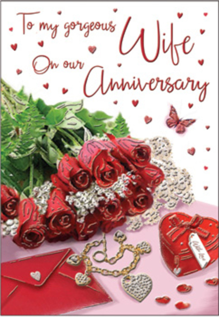 In this richly detailed anniversary composition, a bouquet of classic red roses takes pride of place, as if carefully arranged on a polished surface in a Rickmansworth living room just off the High Street. Each rose is fully open yet still perfectly formed, petals layered in lush spirals of deep scarlet that communicate devotion and time-honoured romance. The blooms are gathered with supple green foliage, the leaves glossy and structured, giving the sense of a hand-tied bouquet freshly prepared by a skilled local florist. Surrounding this floral focal point are delicate, romantic accents: perhaps a trace of lace edging peeks out from beneath the flowers, and scattered heart motifs echo the shape of the blooms themselves. A jewellery set glimmers subtly at the side-maybe a pendant and earrings-its metal and stones catching the light like tiny constellations against the soft background. Nearby, a vivid red box, reminiscent of a treasured ring or keepsake box, rests slightly open or suggestively closed, hinting at an intimate gift exchanged over many years together. The whole arrangement is bathed in gentle, natural light, as if streaming through a window above Rickmansworth's quiet residential streets, softening any edges and enhancing the textures of velvet petals, cool metal, and smooth card. The anniversary card itself is visible, its elegant scripted message adding a personal note to the tableau, while the surrounding décor-trinkets, hearts, and hints of silk or satin ribbon-creates a sense of warmth and quiet celebration. This is not a loud or showy scene, but a deeply romantic, familiar setting, evoking the comfort of long-lasting love and the thoughtful gestures that mark another year together.
